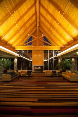 a church with a wooden ceiling and chairs and a fireplace at Edmonton Hotel & Convention Center Edmonton in Edmonton