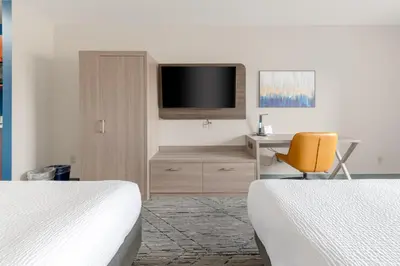 a bedroom with two beds and a desk and a tv at Holiday Inn Express Hotel & Suites-Edmonton South by IHG in Edmonton