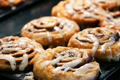 a bunch of donuts with icing on a tray at Holiday Inn Express Hotel & Suites Sherwood Park-Edmonton Area by IHG in Sherwood Park