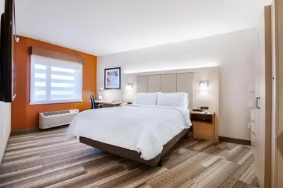 a hotel room with a large bed and a desk at Holiday Inn Express & Suites Langley by IHG in Langley