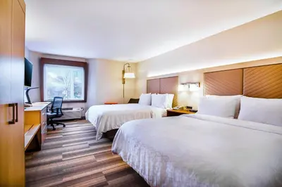 a hotel room with two beds and a desk at Holiday Inn Express & Suites Langley by IHG in Langley