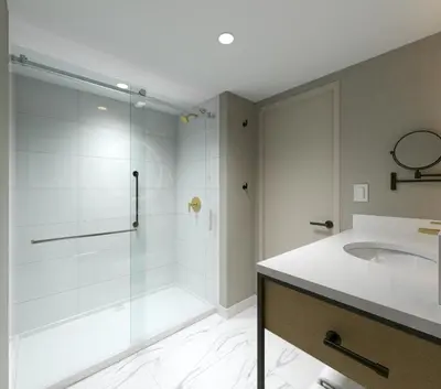 a bathroom with a glass shower and a sink at Hotel Kelowna & Conference Centre in Kelowna