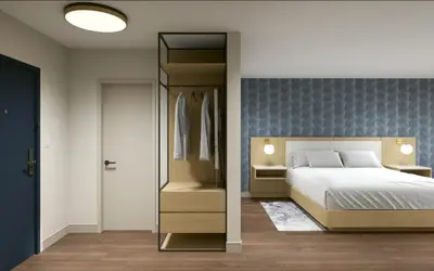 a bedroom with a bed and a closet at Hotel Kelowna & Conference Centre in Kelowna
