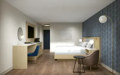 a bedroom with a bed and a desk and a chair at Hotel Kelowna & Conference Centre in Kelowna