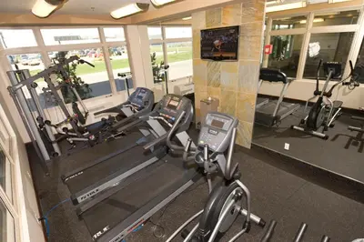 a gym with two treadmills and two ellipticals at Holiday Inn Hotel & Suites-West Edmonton by IHG in Edmonton