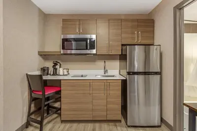 a small kitchen with a refrigerator and a sink at Best Western Plus West Edmonton in Edmonton