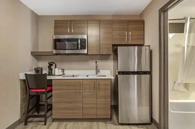 a small kitchen with a refrigerator and a sink at Best Western Plus West Edmonton in Edmonton