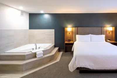 a hotel room with a bed and a bath tub at Holiday Inn Hinton by IHG in Hinton