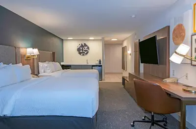 a hotel room with two beds and a desk and a computer at Holiday Inn Hotel and Suites-Kamloops by IHG in Kamloops