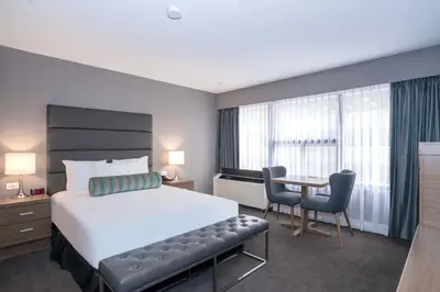a hotel room with a bed and a table and chairs at Sandman Signature Calgary Downtown Hotel in Calgary