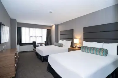 a hotel room with two beds and a desk at Sandman Signature Calgary Downtown Hotel in Calgary