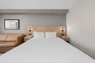 a bedroom with a large bed and a couch at Sandman Hotel Calgary Airport in Calgary