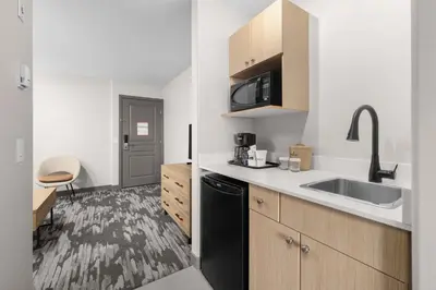 a small kitchen with a sink and a microwave at Sandman Hotel Calgary Airport in Calgary