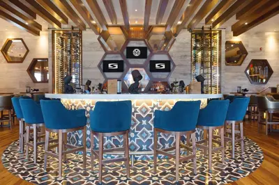 a bar with blue bar stools in a restaurant at Sandman Hotel Calgary Airport in Calgary