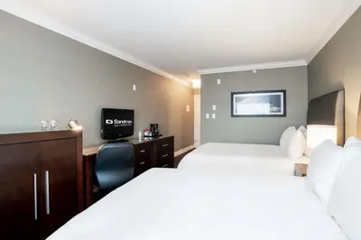 a hotel room with two beds and a television at Sandman Hotel Vancouver Airport in Richmond