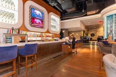 a woman standing at a bar in a restaurant at Sandman Signature Vancouver Airport Hotel & Resort in Richmond