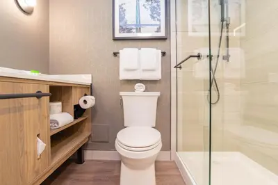 a bathroom with a toilet and a glass shower at Sandman Suites Vancouver on Davie in Vancouver