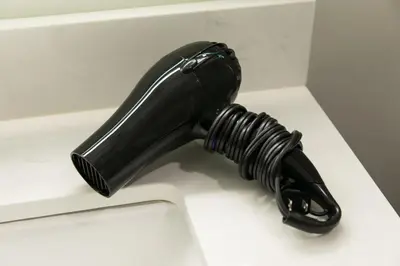 a black hair dryer sitting on a white sink at Days Inn by Wyndham Vancouver Airport in Richmond