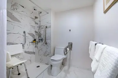 a white bathroom with a toilet and a shower at Best Western Plus Sands in Vancouver