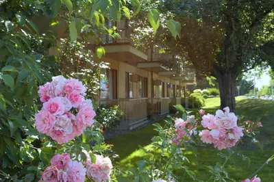 a building with pink flowers in front of it at Dilworth Inn Kelowna in Kelowna