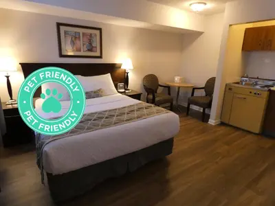 a hotel room with a bed with a green sign on it at Dilworth Inn Kelowna in Kelowna