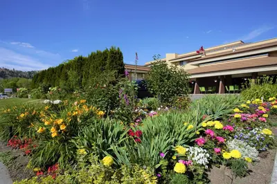 a garden of flowers in front of a building at Dilworth Inn Kelowna in Kelowna