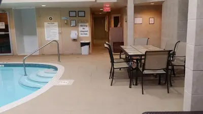 a restaurant with a table and chairs next to a pool at Holiday Inn Express Red Deer by IHG in Red Deer