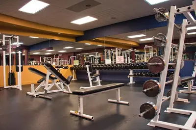 a gym with several rows of treadms and weights at iHOTEL & Conference Centre Red Deer in Red Deer