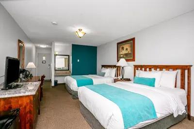 a hotel room with two beds and a flat screen tv at Tonquin Inn in Jasper