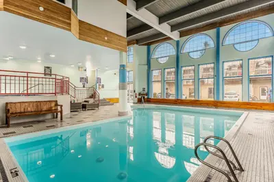 a swimming pool in a building with windows at Tonquin Inn in Jasper