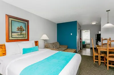 a bedroom with a large bed and a dining room at Tonquin Inn in Jasper