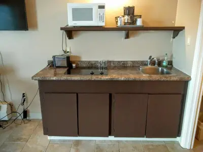 a kitchen with a sink and a microwave at Alaskan Motel in Fox Creek