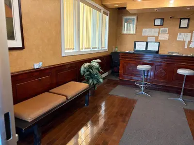 a waiting room with a bench and a desk at Alaskan Motel in Fox Creek