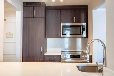 a kitchen with wooden cabinets and a stainless steel appliance at La Grande Residence at the Sutton Place Hotel in Vancouver
