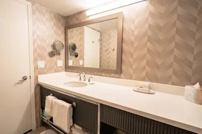 a bathroom with a sink and a mirror at La Grande Residence at the Sutton Place Hotel in Vancouver