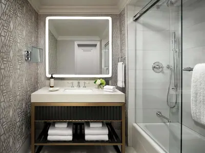 a bathroom with a sink and a mirror and a tub at Fairmont Hotel Macdonald in Edmonton