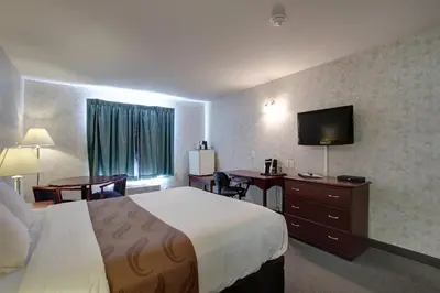 a hotel room with a bed and a flat screen tv at Ramada by Wyndham Nisku Edmonton Airport in Nisku