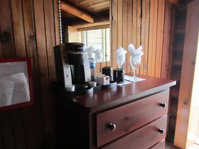 a wooden dresser with a coffee maker on top of it at The Surf Lodge and Pub in Gabriola