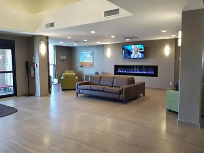 a living room with a couch and a fireplace at Encore Suites by Service Plus Inns in Grande Prairie