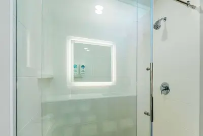 a bathroom with a shower with a window at Comfort Suites Kelowna in Kelowna