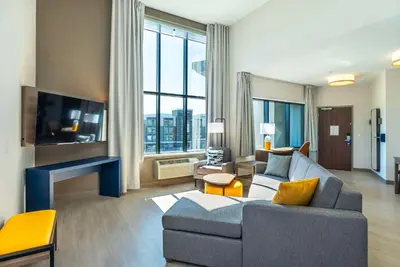 a living room with a couch and a large window at Comfort Suites Kelowna in Kelowna