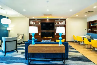 a lobby with a blue couch and chairs at Comfort Suites Kelowna in Kelowna