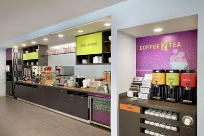 a coffee shop with a counter and a coffeeastery at Home2 Suites by Hilton Fort St. John in Fort Saint John
