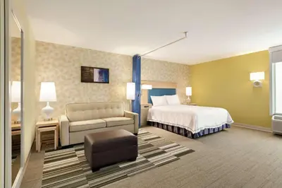 a hotel room with a bed and a couch at Home2 Suites by Hilton Fort St. John in Fort Saint John