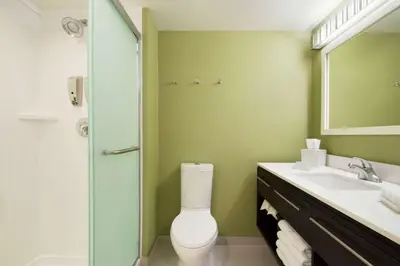a bathroom with a toilet and a sink and a mirror at Home2 Suites by Hilton Fort St. John in Fort Saint John