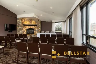 a conference room with chairs and a fireplace at Grande Rockies Resort-Bellstar Hotels & Resorts in Canmore