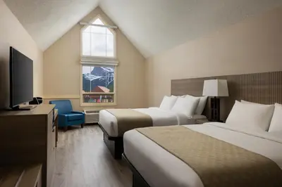 a hotel room with two beds and a television at Grande Rockies Resort-Bellstar Hotels & Resorts in Canmore