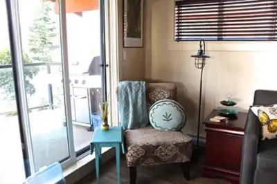a living room with a chair and a table at Fish Tales Cottage in Port Renfrew