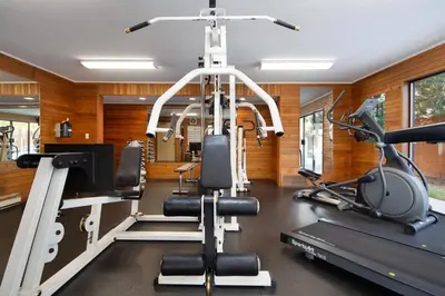 a gym with a treadmill and two tread machines at Siesta Suites in Kelowna