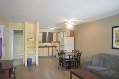 a living room and kitchen with a couch and a table at Siesta Suites in Kelowna